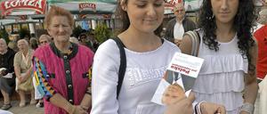 Wie werden die jungen Polen wählen? Ein Wahlkämpfer versucht diese jungen Frauen mit Flyern von Jaroslaw Kaczynski zu überzeugen.