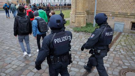 Police officers of a special unit lead pupils away from a vocational school in Potsdam, northeastern Germany, during a major police operation on February 27, 2023, following an amok alert.