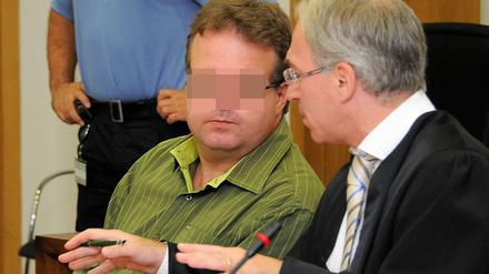 Der Rechtsanwalt Karsten Beckmann (r) unterhält sich am Montag (01.08.2011) im Landgericht Potsdam mit dem Angeklagten Carsten W., der zum Auftakt des Prozesses um das Entführungsdrama von Kleinmachnow ein umfassendes Geständnis ablegte.