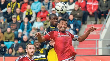 Übersprungshandlung. Dortmunds Adrian Ramos (oben) und Ingolstadts Marvin Matip im Duell um den Ball. Foto: AFP/Schiffmann