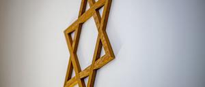  Ein Davidstern hängt an einer Wand im Gebetsraum einer Synagoge (Symbolbild).