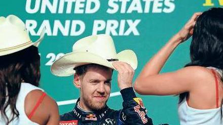 Ich hab’ hier den Hut auf. Vettel schäkert in Austin mit den Grid-Girls. Foto: AFP