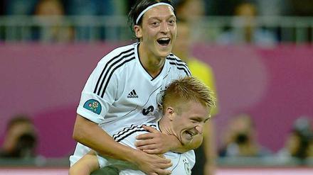 Und er so: Strahl! Am Freitag feierte Mesut Özil mit Marco Reus den Sieg gegen Griechenland. Heute ist er in der DFB-Pressekonferenz zu Gast.