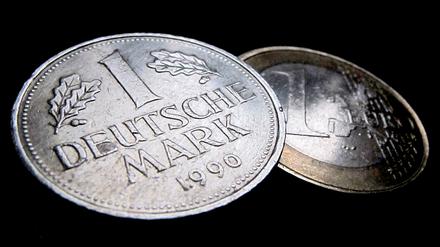 Eine Ein-Euro-Münze (r) und eine Deutsche Mark (D-Mark), aufgenommen am 17.12.2010 in Kaufbeuren (Bayern).