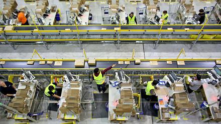 Mitarbeiter des Amazon-Logistikzentrums in Leipzig (Sachsen) verpacken Waren für den Paketversand.