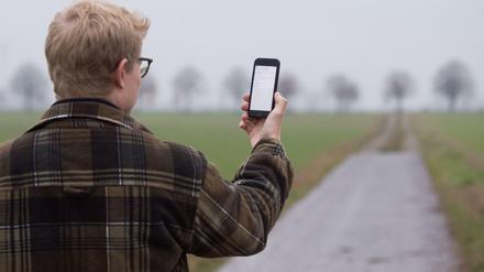 Ein Mann lässt sein Smartphone nach Netzbetreibern suchen.