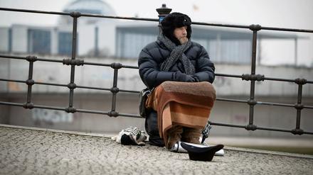 Bedürftiger im Regierungsviertel. Ein Bettler bittet in der Nähe des Reichstags Passanten um eine Spende. 