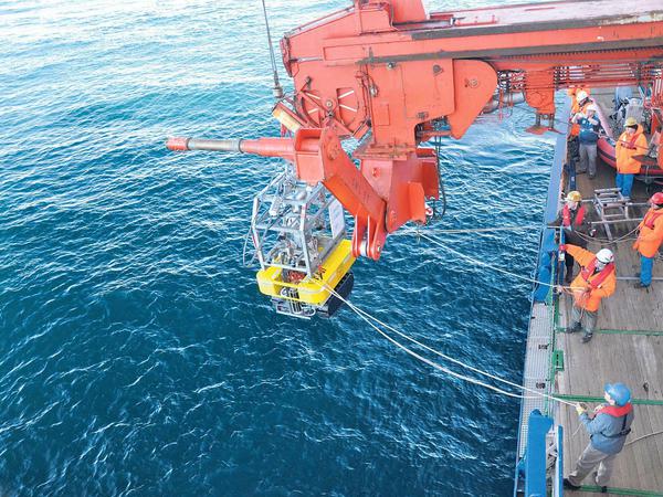 Ein Tiefsee-Crawler wird mithilfe eines Krans von Bord des Forschungsschiffs Polarstern ins Meer gesetzt.