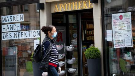 Zettel mit der Aufschrift "Masken" und "Hand-Desinfektion" hängen im Schaufenster einer Apotheke in der Hamburger Innenstadt.
