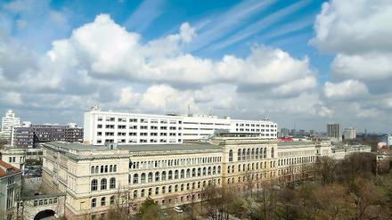 Das Hauptgebäude der Technischen Universität Berlin unter wolkenverhangenem Himmel.