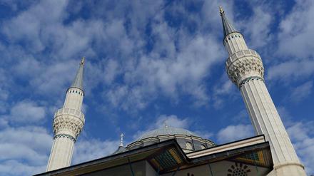 Minarette und Kuppel einer Moschee vor blauem Himmel.