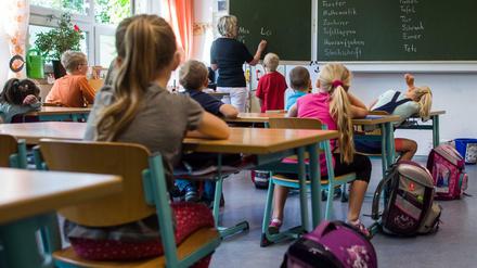 Grundschulkinder sitzen in einem Klassenraum.