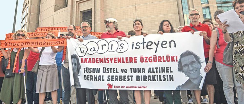 Demonstrierende stehen mit Transparenten vor einem Gerichtsgebäude in Istanbul.