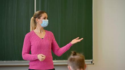 Lehrerin mit Mundschutzmaske im Präsenzunterricht in Stuttgart, Baden-Württemberg.