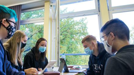 Schülerinnen und Schüler einer 13. Klasse in Hamburg arbeiten mit Mund-Nasenschutz an Laptops in ihrem Klassenraum.