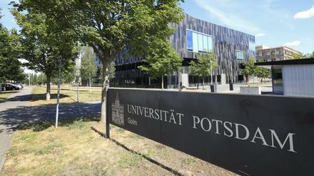 Das Schild der Universität Potsdam im Vordergrund und die Gebäude im Hintergrund.